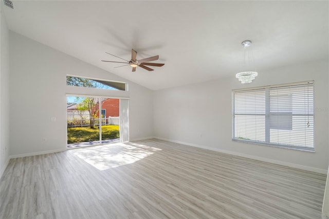 unfurnished room with ceiling fan with notable chandelier, light hardwood / wood-style flooring, and high vaulted ceiling