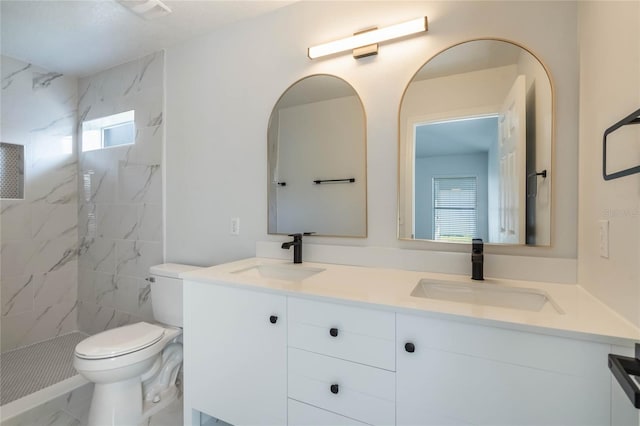 bathroom featuring tiled shower, vanity, and toilet