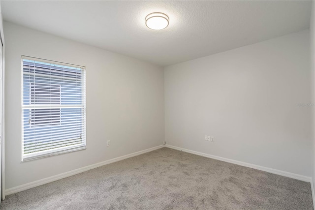 carpeted spare room with a textured ceiling