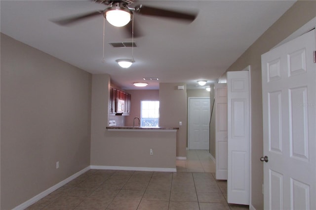 unfurnished room featuring light tile patterned flooring, baseboards, visible vents, and ceiling fan