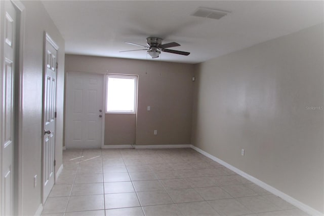 spare room with ceiling fan, visible vents, baseboards, and light tile patterned flooring