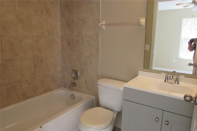 bathroom with a ceiling fan, toilet,  shower combination, and vanity