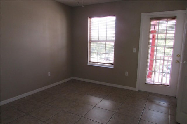 empty room with dark tile patterned flooring