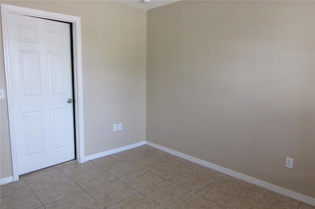 unfurnished room featuring light tile patterned flooring and baseboards