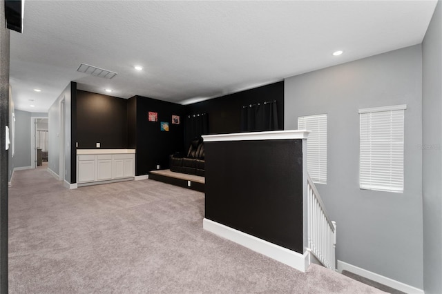 interior space with light carpet and a textured ceiling