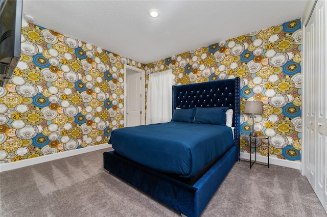 bedroom with a closet, carpet, and a textured ceiling