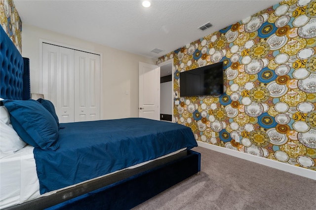 carpeted bedroom with a closet and a textured ceiling