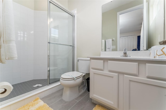 bathroom featuring tile patterned floors, vanity, toilet, and an enclosed shower