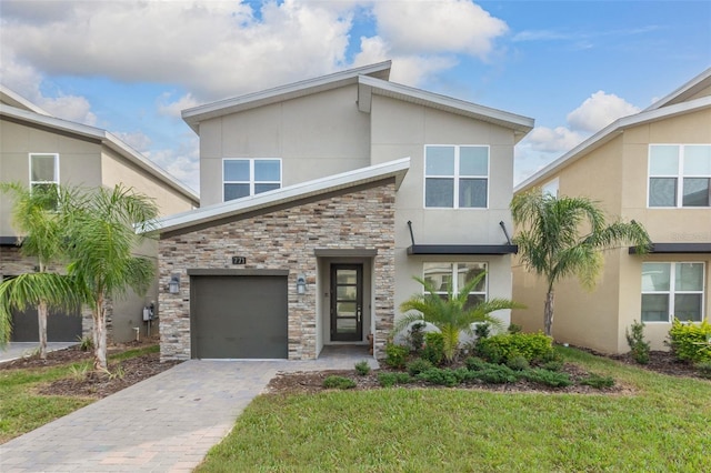 contemporary home with a garage and a front yard