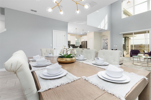 dining area with a chandelier and a high ceiling