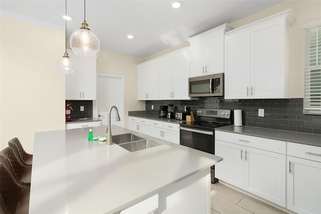 kitchen featuring pendant lighting, white cabinetry, sink, a kitchen bar, and stainless steel appliances