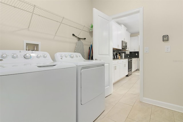 laundry area featuring washer and clothes dryer and light tile patterned flooring