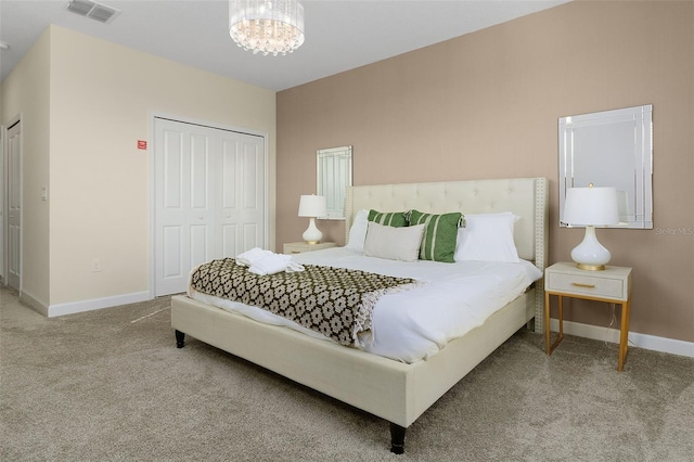 bedroom with a closet, a chandelier, and carpet