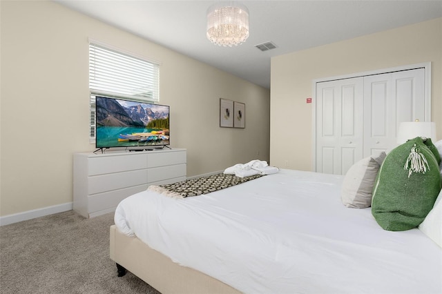 carpeted bedroom featuring a chandelier and a closet