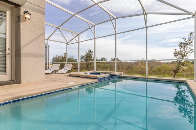 view of swimming pool with an in ground hot tub, a patio area, and glass enclosure