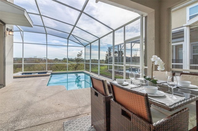 view of pool with an in ground hot tub, a patio area, and glass enclosure