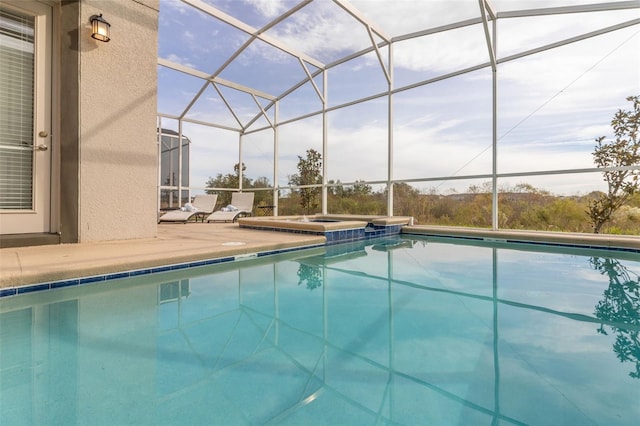 view of swimming pool with an in ground hot tub, a lanai, and a patio area