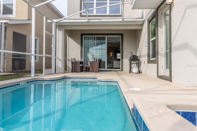 view of swimming pool with area for grilling, a patio, and glass enclosure