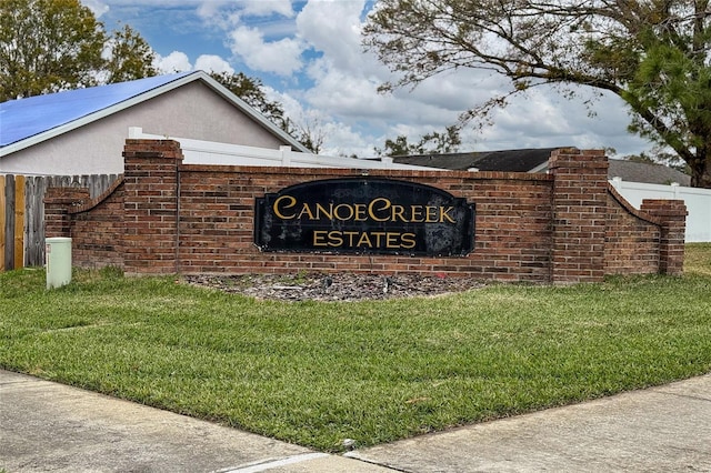 community / neighborhood sign featuring a yard