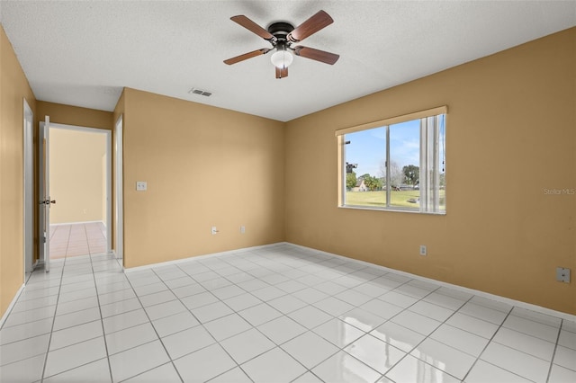 unfurnished room with light tile patterned flooring, ceiling fan, and a textured ceiling