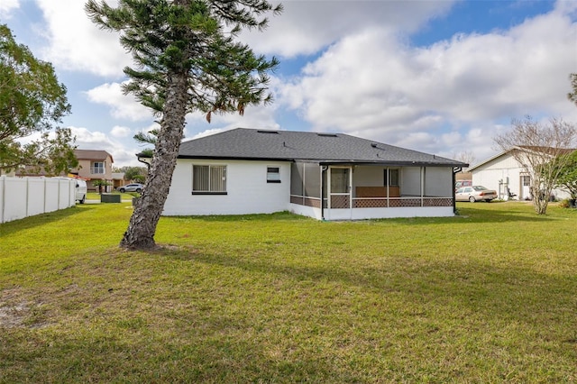 back of house with a yard and a sunroom