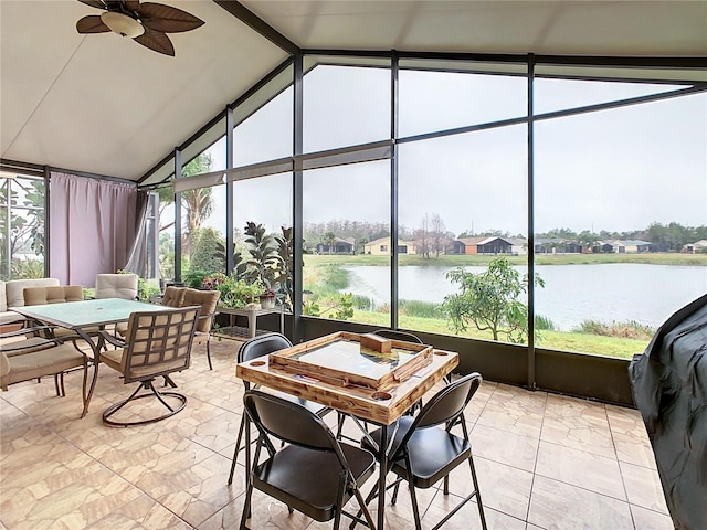 sunroom featuring lofted ceiling with beams, ceiling fan, and a water view