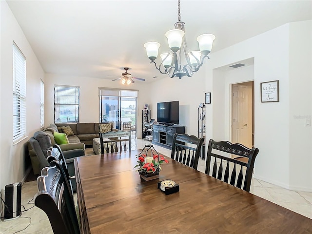 tiled dining room featuring ceiling fan with notable chandelier