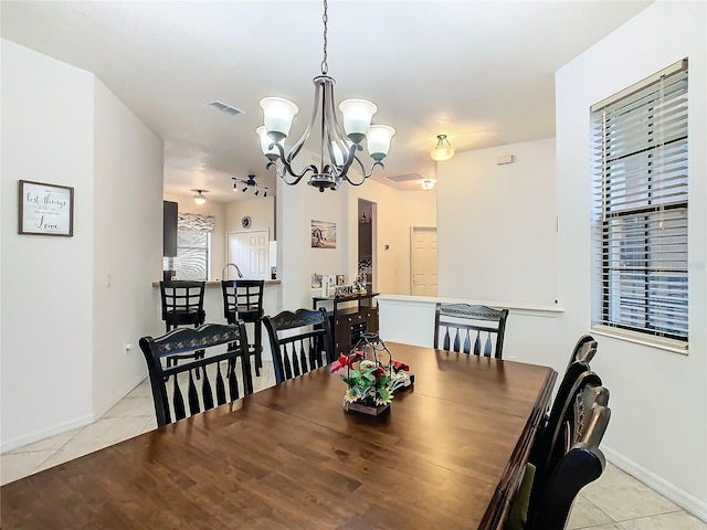 dining room with light tile patterned flooring and a chandelier