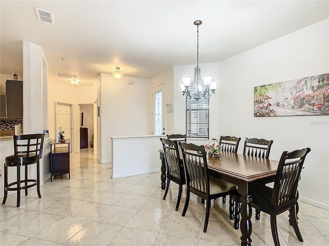 tiled dining space with a chandelier