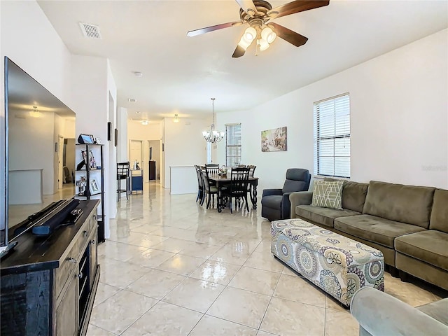 living room featuring ceiling fan with notable chandelier and light tile patterned floors