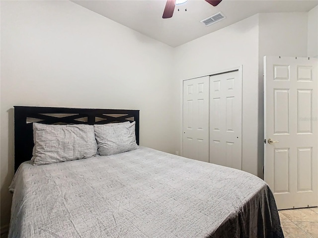 bedroom featuring light tile patterned flooring, ceiling fan, and a closet