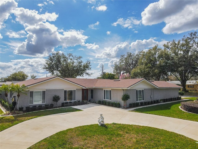 single story home featuring a front yard, brick siding, and driveway