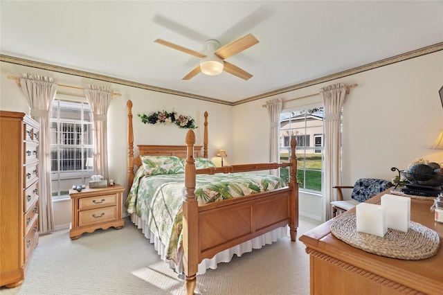 carpeted bedroom with ceiling fan and ornamental molding