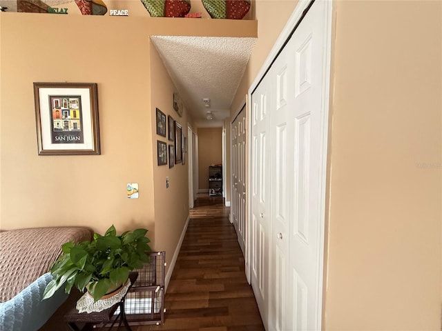 hallway with dark hardwood / wood-style flooring and a textured ceiling