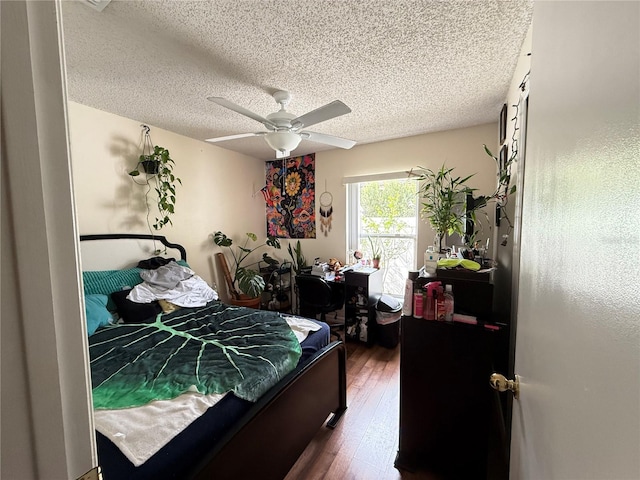 bedroom with dark wood-type flooring, ceiling fan, and a textured ceiling