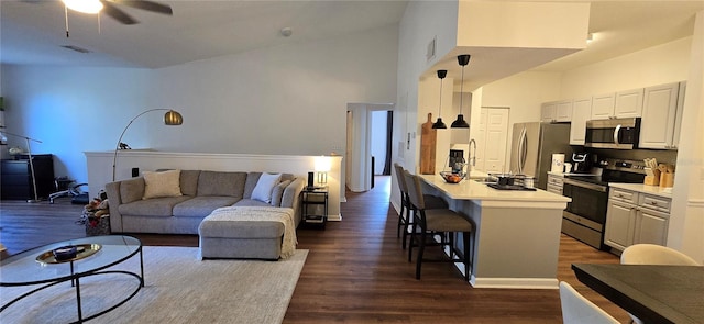 living room with high vaulted ceiling, dark hardwood / wood-style floors, and ceiling fan