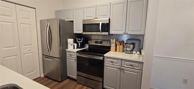 kitchen with white cabinetry, appliances with stainless steel finishes, dark wood-type flooring, and backsplash