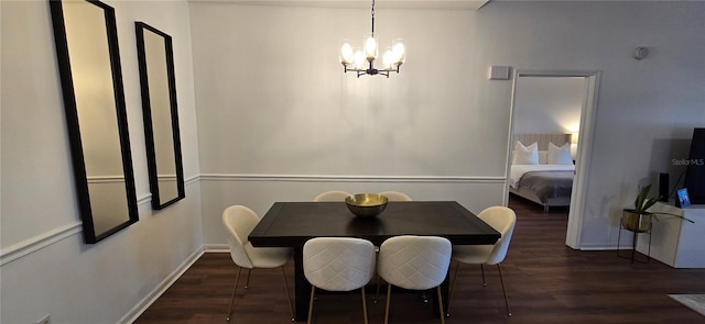 dining space featuring dark wood-type flooring and an inviting chandelier