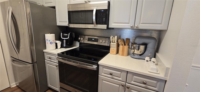 kitchen with stainless steel appliances, white cabinetry, and decorative backsplash