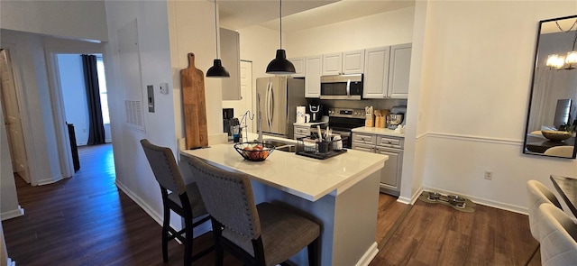 kitchen with appliances with stainless steel finishes, kitchen peninsula, hanging light fixtures, and a breakfast bar area