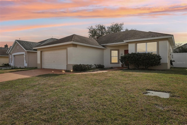 view of front of home with a garage and a lawn