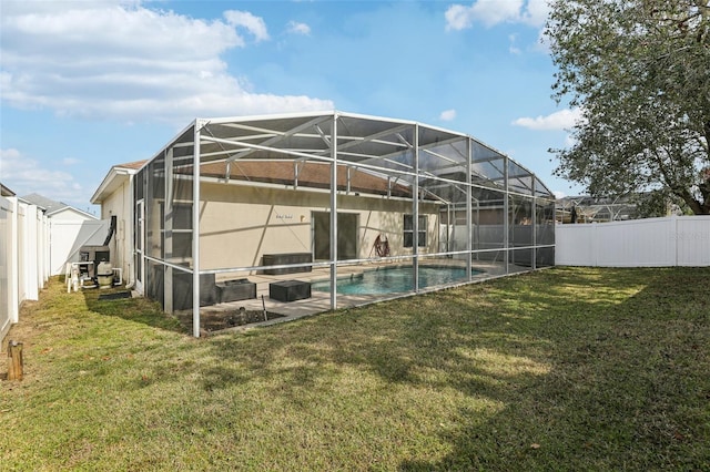 back of property featuring a fenced in pool, a yard, a patio, and glass enclosure