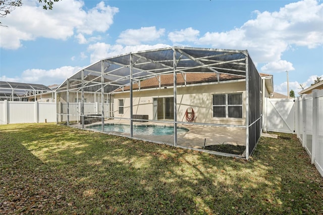 rear view of property with a fenced in pool, a lawn, and glass enclosure