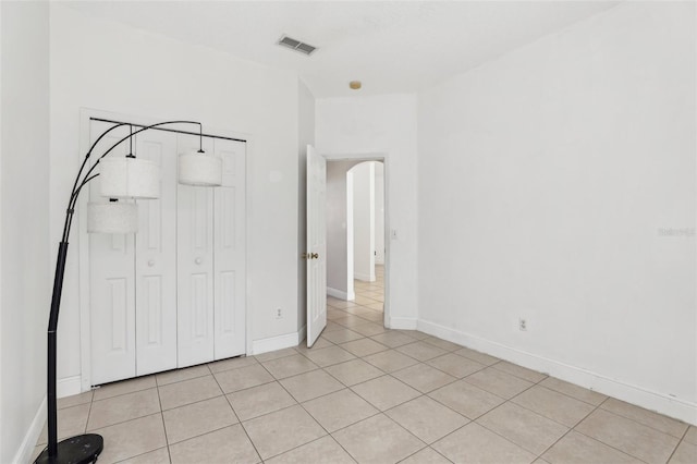 unfurnished bedroom featuring light tile patterned flooring and a closet