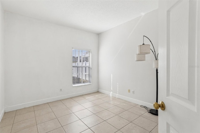 tiled spare room with a textured ceiling