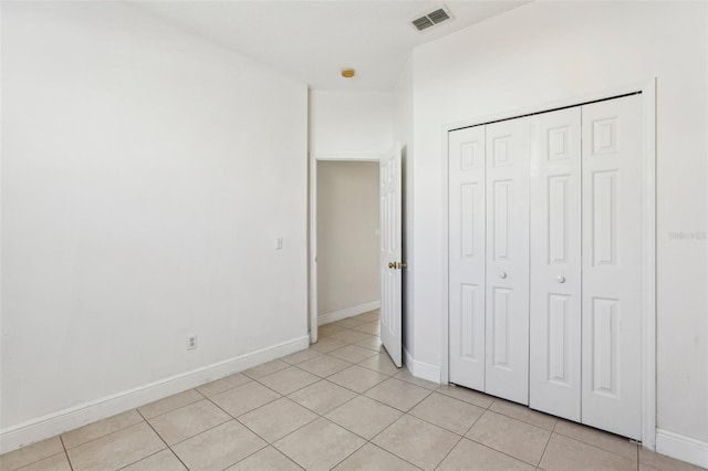 unfurnished bedroom with a closet and light tile patterned floors