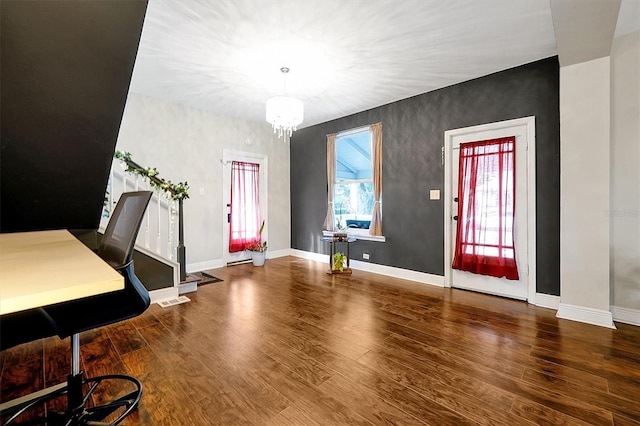 interior space featuring baseboards, a notable chandelier, and wood finished floors