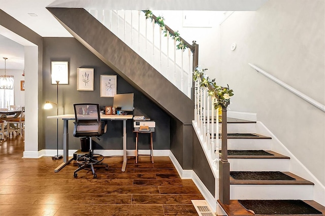 office area with a notable chandelier, visible vents, baseboards, and wood finished floors