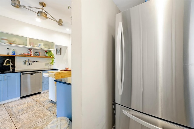 kitchen featuring a sink, stainless steel appliances, and open shelves