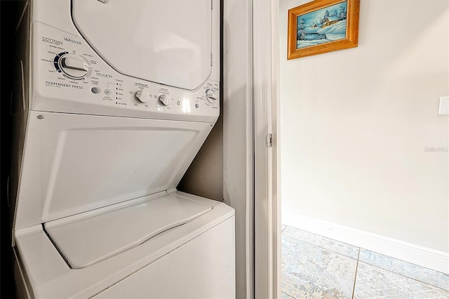 laundry room featuring laundry area, baseboards, and stacked washer and clothes dryer